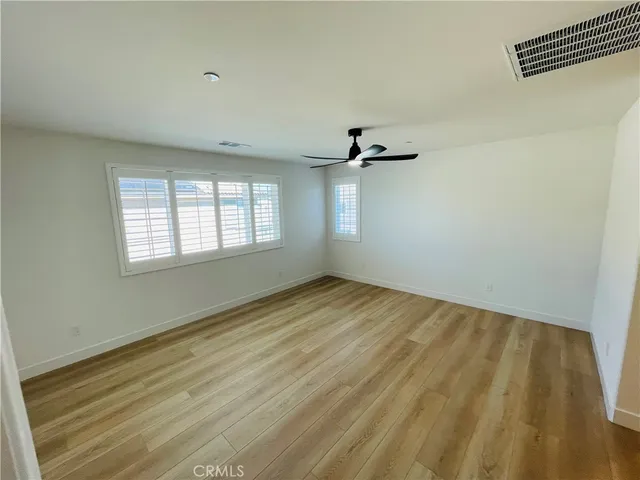 a view of a big room with wooden floor and a ceiling fan