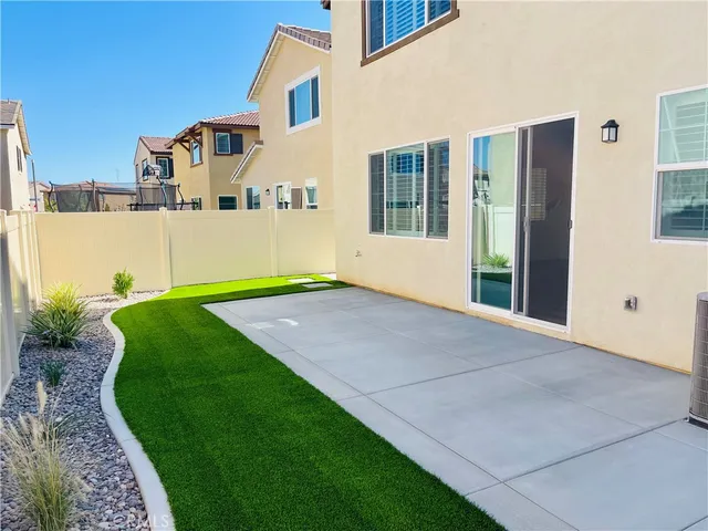 a patio with a table and chairs under an umbrella