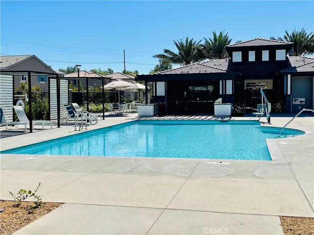 a front view of a house with a garden and lake view
