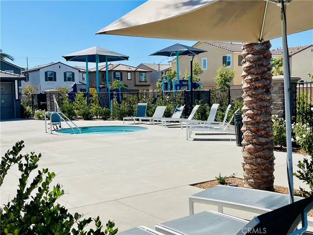 a view of a patio with couches table and chairs under an umbrella with a barbeque