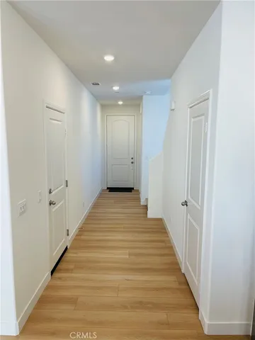 a view of a hallway with wooden floor