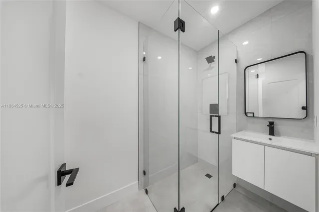 a bathroom with a shower sink vanity and mirror