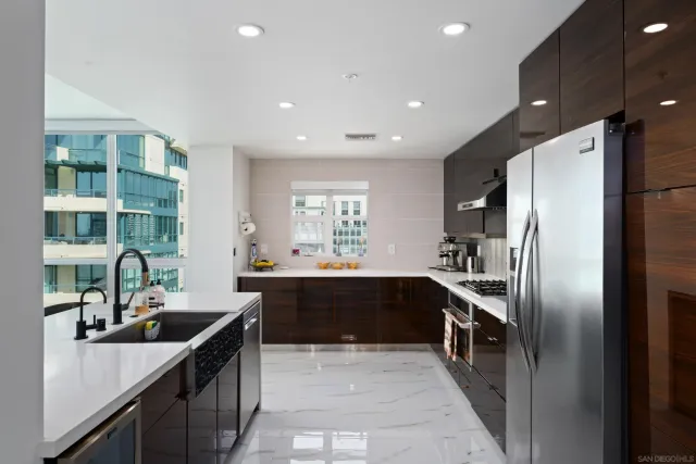 a large kitchen with kitchen island a sink and a large window