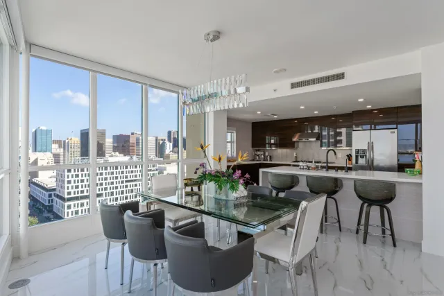 a dining room with furniture and large windows