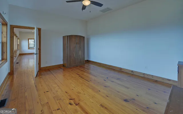 a view of a balcony with wooden floor & fence