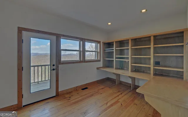 an empty room with wooden floor and cabinet