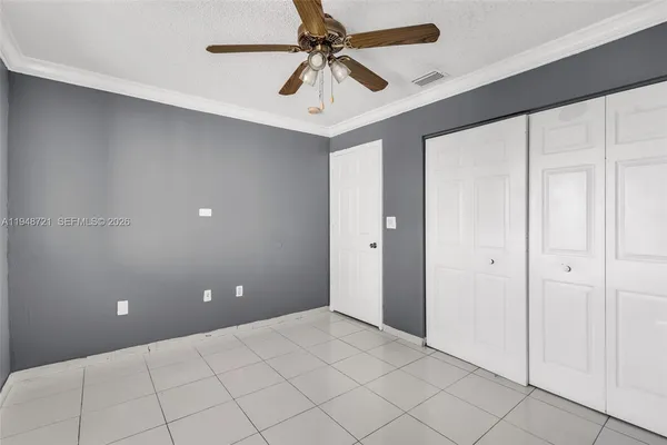 a view of an empty room and a ceiling fan