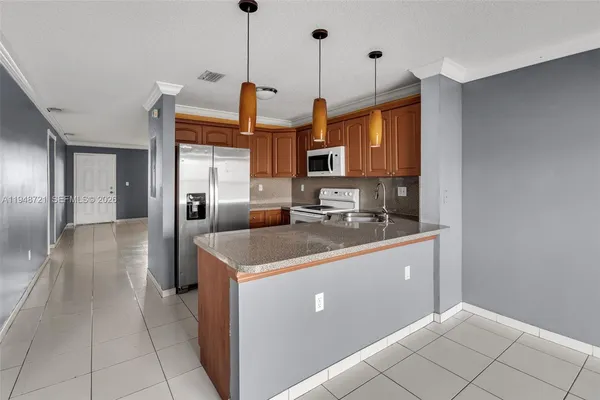 a kitchen with stainless steel appliances granite countertop a sink and a refrigerator