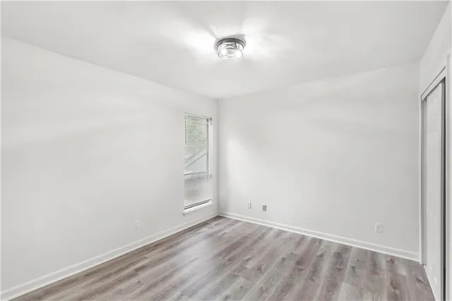 a view of a room with wooden floor and white walls