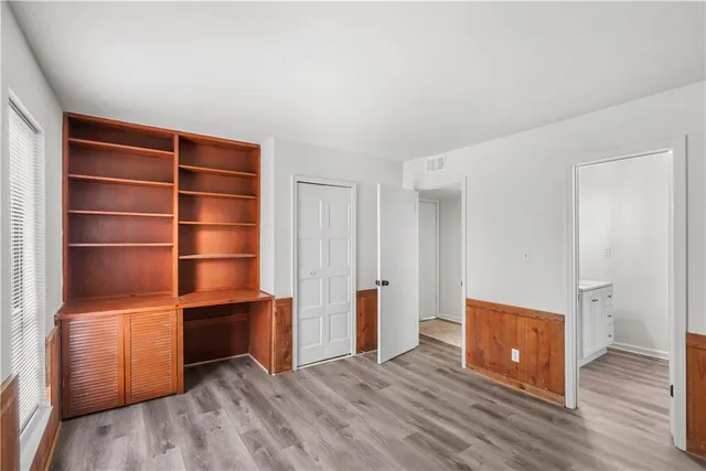 a view of an empty room and wooden floor and closet