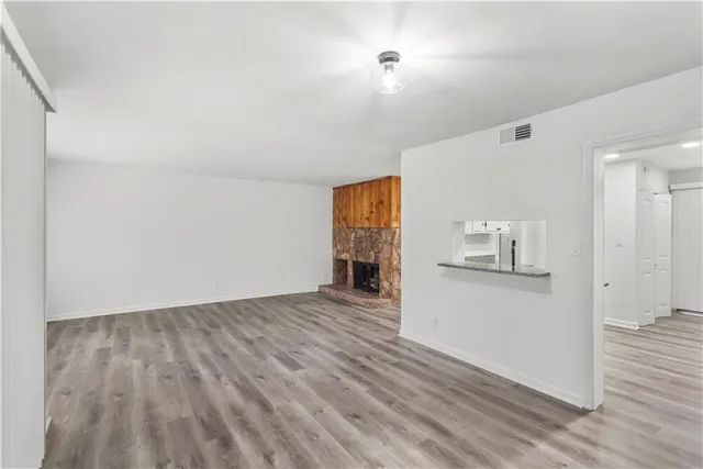a view of a kitchen with wooden floor and a refrigerator