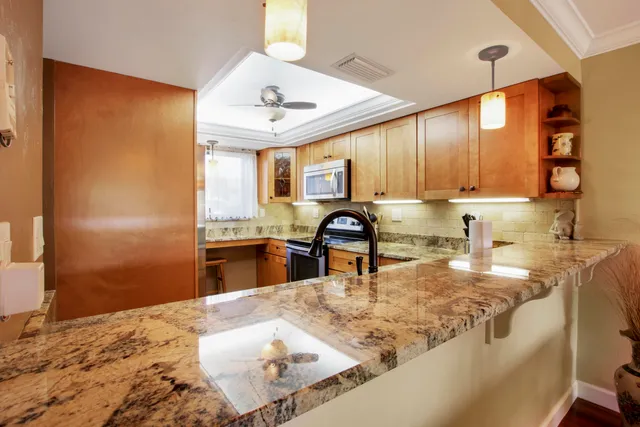 a kitchen with stainless steel appliances granite countertop a sink refrigerator and cabinets