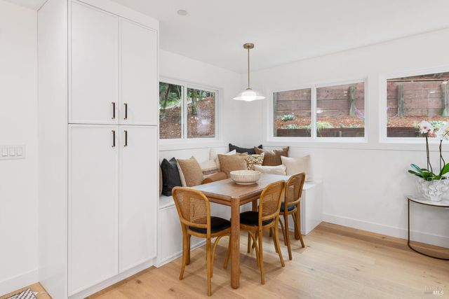 a kitchen with stainless steel appliances kitchen island granite countertop a table chairs and a refrigerator