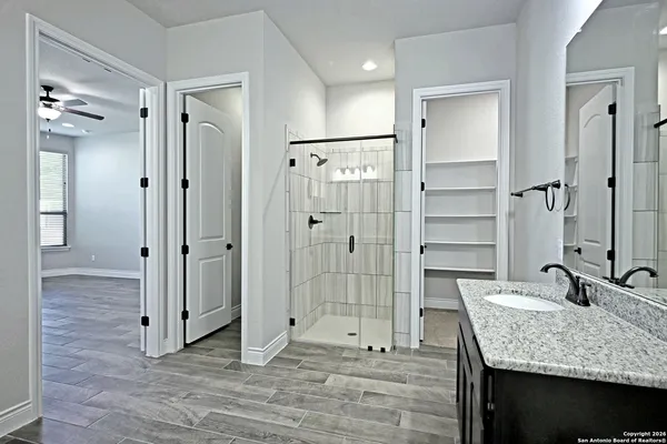 a bathroom with a granite countertop sink and shower