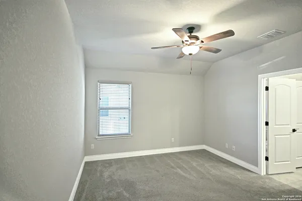 an empty room with closet and a chandelier fan