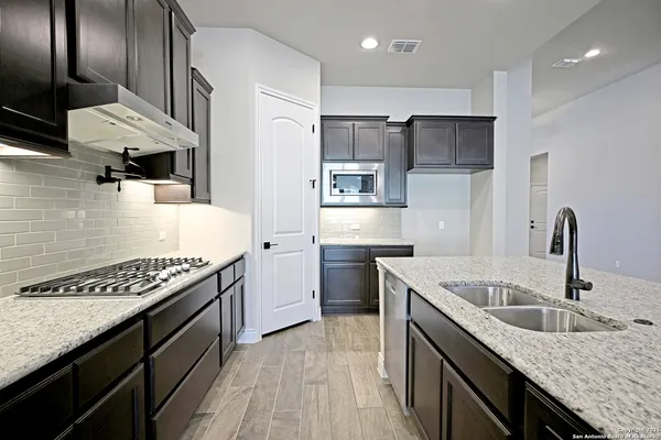 a kitchen with stainless steel appliances granite countertop a sink stove and refrigerator