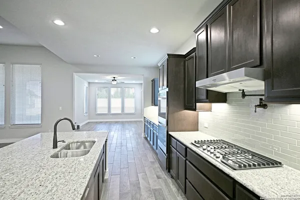 a kitchen with stainless steel appliances granite countertop a sink dishwasher and cabinets with wooden floor