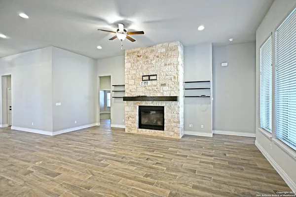 wooden floor fireplace and windows in an empty room
