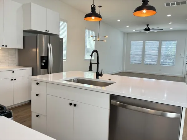 a kitchen with kitchen island a sink stainless steel appliances and cabinets