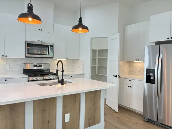a kitchen with stainless steel appliances a stove a refrigerator and a sink