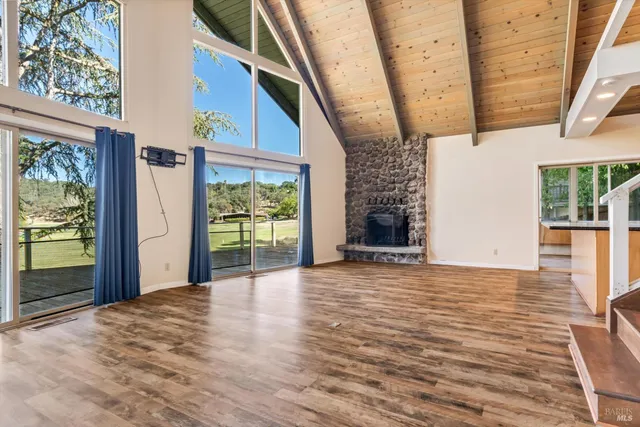 a view of a livingroom with wooden floor and a fireplace