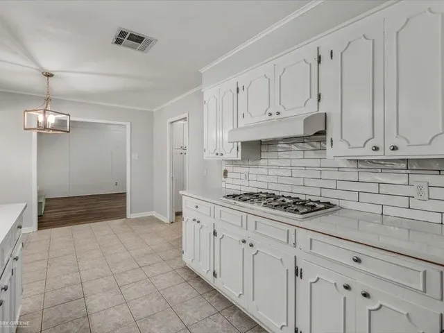 a kitchen with white cabinets and appliances