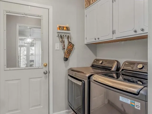 a view of an empty room with a chandelier fan