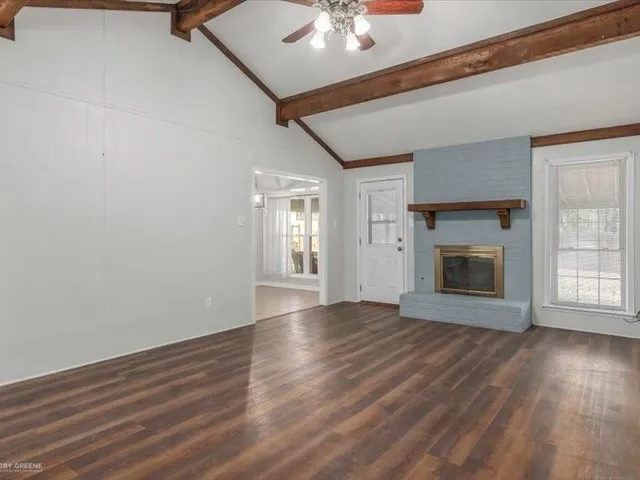 a view of an empty room with a fireplace and a window