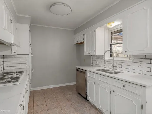 a kitchen with a sink cabinets and stove