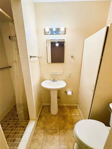 a bathroom with a sink toilet and mirror