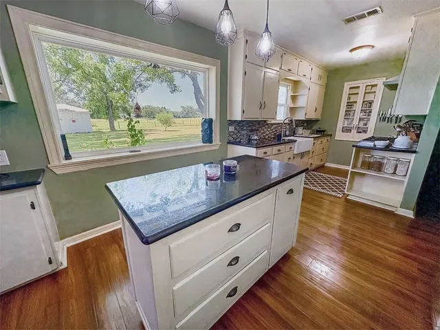 a kitchen with stainless steel appliances granite countertop a stove and a wooden floors