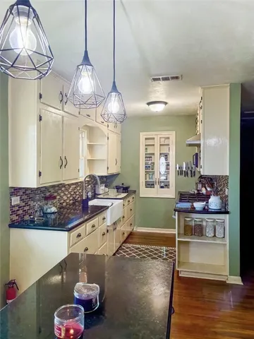 a large room with kitchen island stainless steel appliances and wooden floor