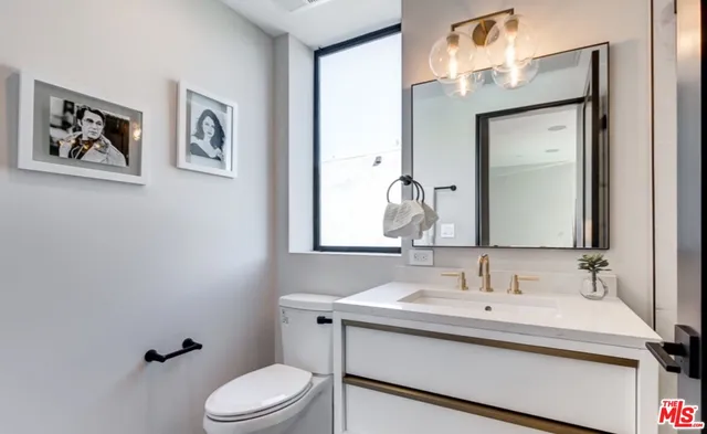 a bathroom with a toilet a sink and mirror
