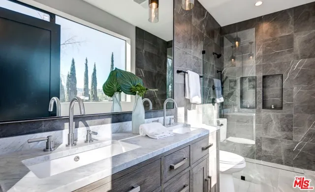 a bathroom with double vanity and a mirror