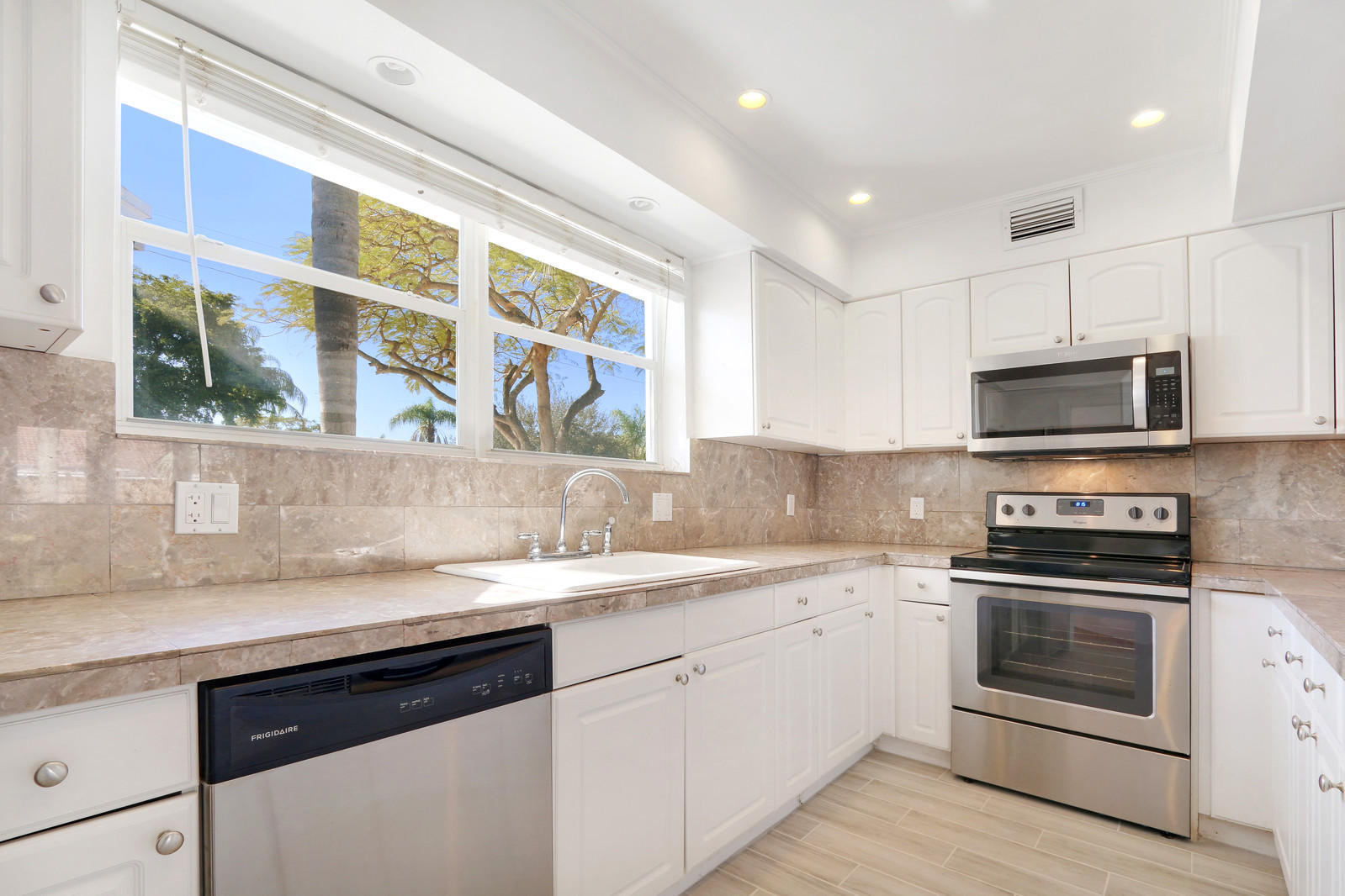 1329 Northwest 6th Street Boca Raton, FL 33486 - Photo 8 of 27 a kitchen with stainless steel appliances granite countertop a sink and a stove