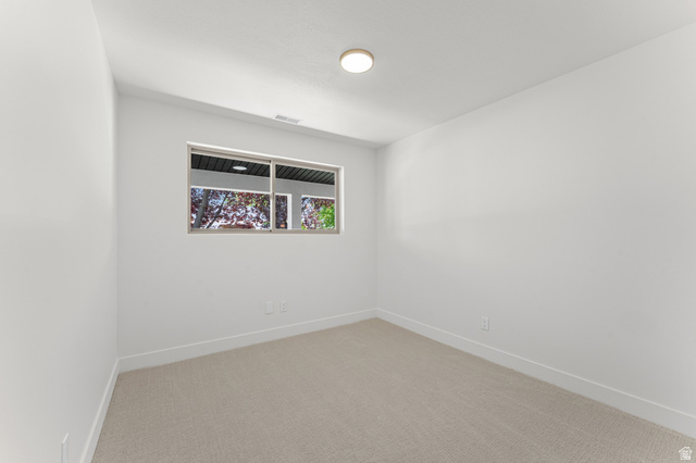 1898 West 600 South Provo, UT 84601 - Photo 23 of 32 Neutral-toned carpeting paired with white walls, a single window, and a flush-mount ceiling light fixture