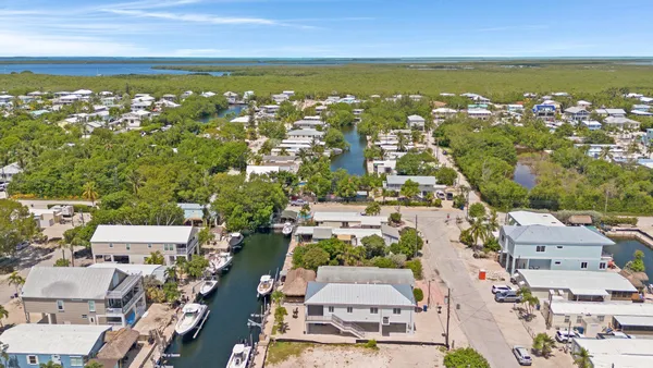 an aerial view of residential building with outdoor space and ocean view