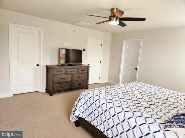 a bedroom with a bed and a flat tv screen on dresser