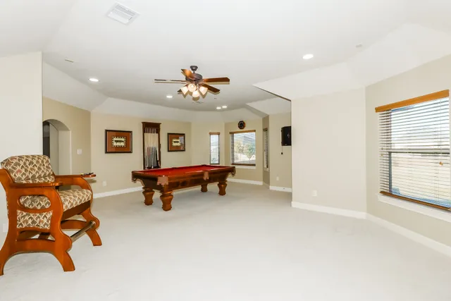 a view of an empty room with a window and a kitchen