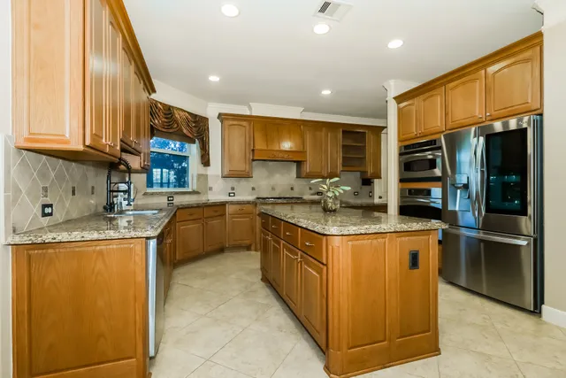 a kitchen with stainless steel appliances granite countertop a stove and a refrigerator
