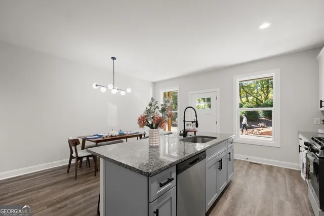 a kitchen with granite countertop a sink cabinets and wooden floor
