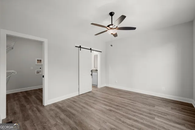 a view of empty room with wooden floor and ceiling fan