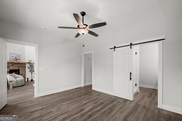 a view of a room with wooden floor and ceiling fan