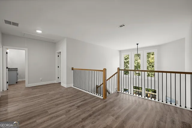 a view of a room with wooden floor stairs and windows