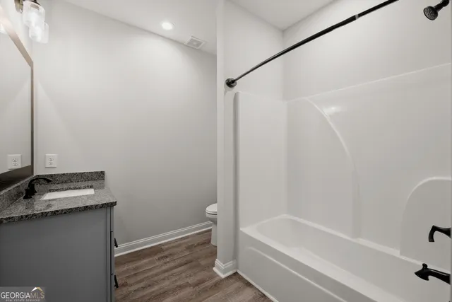 a bathroom with a granite countertop sink and a bathtub