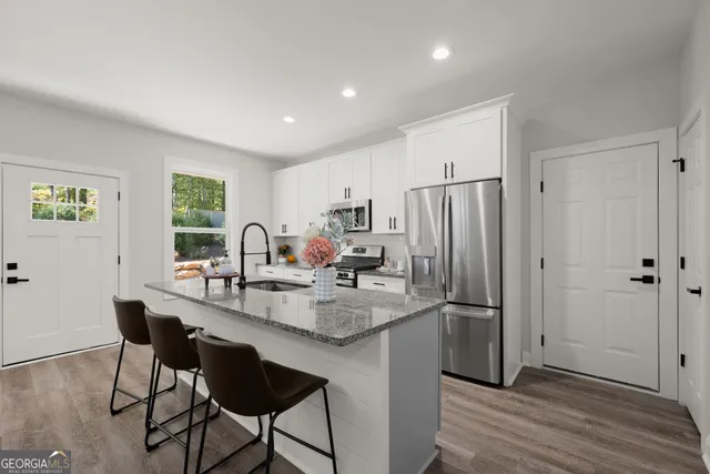 a kitchen with refrigerator and chairs