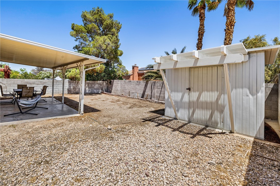 1624 Palmae Way Las Vegas, NV 89128 - Photo 16 of 18 Enjoy outdoor living with a covered patio and a detached shed in this spacious backyard.