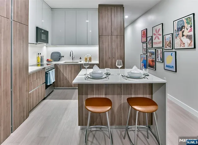 a kitchen with stainless steel appliances granite countertop a table chairs and a refrigerator