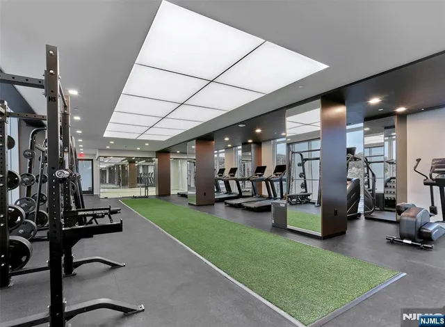 a view of a room with gym equipment and a rug