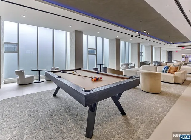 a living room with furniture pool table and a large window